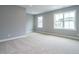 Spacious bedroom featuring neutral walls, carpeted floors, and two large windows offering ample natural light at 1221 Barreto Dr, Wendell, NC 27591