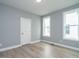 Empty bedroom with neutral walls, wood floors and two windows providing natural light at 1221 Barreto Dr, Wendell, NC 27591