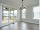 Light-filled dining room with deck access through sliding glass doors, modern lighting and neutral walls at 1221 Barreto Dr, Wendell, NC 27591