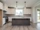 Modern kitchen features a center island, white cabinets, stylish backsplash and stainless appliances at 1221 Barreto Dr, Wendell, NC 27591