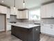 Modern kitchen with white cabinets, center island, granite countertops, and pendant lighting at 1221 Barreto Dr, Wendell, NC 27591