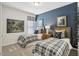 Comfortable bedroom featuring two twin beds, plaid bedding, a blue accent wall, and modern decor at 1234 Sirius Lot 6 Dr, Sanford, NC 27330