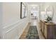 Elegant hallway featuring hardwood floors, white wainscoting, and stylish decor leading to the living area at 1234 Sirius Lot 6 Dr, Sanford, NC 27330