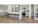 Well-lit kitchen with gray cabinets, stainless steel appliances, a kitchen island with stools, and a dining area at 1234 Sirius Lot 6 Dr, Sanford, NC 27330