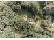 Aerial view of a home surrounded by lush trees, a garden, and green lawns at 133 Acorn Ln, Pittsboro, NC 27312