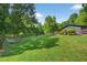 Expansive backyard with lush lawn, mature trees, and a charming hammock, ideal for relaxation at 133 Acorn Ln, Pittsboro, NC 27312