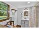 Charming bathroom featuring wainscoting, a vanity, and a tiled shower with natural light at 133 Acorn Ln, Pittsboro, NC 27312