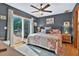 Cozy bedroom featuring a ceiling fan, sliding glass doors to a deck and a comfortable floral quilt at 133 Acorn Ln, Pittsboro, NC 27312