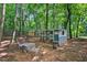 Backyard chicken coop with enclosed pen, seating area, and wooded surroundings on a sunny day at 133 Acorn Ln, Pittsboro, NC 27312