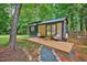 Charming tiny home with a wooden deck and cozy seating, surrounded by lush greenery at 133 Acorn Ln, Pittsboro, NC 27312