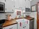 Close-up of kitchen featuring butcher block countertops, white cabinets, and stainless steel sink at 133 Acorn Ln, Pittsboro, NC 27312