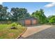 Two-car garage with gray siding, decorative sunflower, and large paved driveway at 133 Acorn Ln, Pittsboro, NC 27312