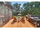 Outdoor patio with lounge chairs and grill and views to the expansive, treed backyard at 133 Acorn Ln, Pittsboro, NC 27312