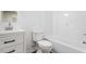Bright bathroom features a white sink, toilet, and bathtub with updated fixtures over wood grain floors at 1408 South St, Durham, NC 27707