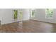 Bright living room with wood-look floors, white walls, and access to the outdoors through French doors at 1408 South St, Durham, NC 27707