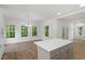 Open concept living area features wood grain floors, recessed lighting, and bright windows overlooking green trees at 1408 South St, Durham, NC 27707