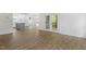 Open-concept layout shows kitchen, living, and dining areas with wood-look flooring and bright, white walls at 1408 South St, Durham, NC 27707