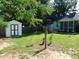 Well-kept backyard with a convenient storage shed, mature trees, and a manicured lawn at 204 Southland Dr, Zebulon, NC 27597