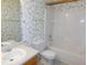 Bathroom featuring floral wallpaper, single sink vanity, toilet and tub with shower at 204 Southland Dr, Zebulon, NC 27597