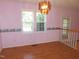 Dining room with chandelier, light pink walls and many windows at 204 Southland Dr, Zebulon, NC 27597