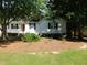 A traditional home featuring a cozy front porch with classic white railings and a verdant lawn at 204 Southland Dr, Zebulon, NC 27597