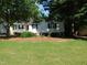 Traditional home enhanced with white trim and lush landscaping, nestled under mature shady trees at 204 Southland Dr, Zebulon, NC 27597
