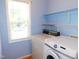 Functional laundry room with washer, dryer, and shelving unit at 204 Southland Dr, Zebulon, NC 27597