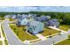 Aerial view of a blue two-story home, showcasing its manicured lawn and neighborhood at 300 Ledge Manor Dr, Holly Springs, NC 27540