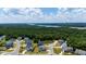 Community aerial view showcasing houses, lake and distant nuclear power plant at 300 Ledge Manor Dr, Holly Springs, NC 27540