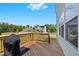 Wooden back deck with a grill and view of the street and other homes in the neighborhood at 300 Ledge Manor Dr, Holly Springs, NC 27540