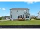 Spacious backyard featuring light blue siding, well-maintained lawn, and wooden deck at 300 Ledge Manor Dr, Holly Springs, NC 27540