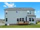 Back of the home with a wooden deck, well-manicured lawn, and light blue siding at 300 Ledge Manor Dr, Holly Springs, NC 27540