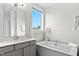 Bathroom with vanity, soaking tub, quartz counters, and views to the outside at 300 Ledge Manor Dr, Holly Springs, NC 27540