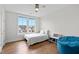 Bright bedroom with hardwood floors, ceiling fan, and natural light from large windows at 300 Ledge Manor Dr, Holly Springs, NC 27540
