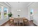 Bright dining room with a modern chandelier, decorative plants, and large windows at 300 Ledge Manor Dr, Holly Springs, NC 27540