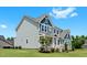 Angle view of the house with manicured landscaping and inviting staircase leading to the front door at 300 Ledge Manor Dr, Holly Springs, NC 27540