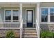 Close-up of the entrance featuring a stylish front door, stone accents, and well-lit porch at 300 Ledge Manor Dr, Holly Springs, NC 27540
