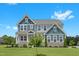 Charming two-story home featuring stone accents, a welcoming porch, and a beautifully landscaped front yard at 300 Ledge Manor Dr, Holly Springs, NC 27540