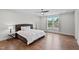 Main bedroom features a comfy bed, fan, neutral palette, and hardwood floors at 300 Ledge Manor Dr, Holly Springs, NC 27540