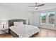 Main bedroom showcases a comfy bed, fan, neutral palette, and hardwood floors at 300 Ledge Manor Dr, Holly Springs, NC 27540