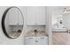 Mud room with white cabinetry, granite countertop, round mirror and hardwood floors at 300 Ledge Manor Dr, Holly Springs, NC 27540