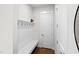 Mud room features a bench with hooks, a white paneled wall, and hardwood floors at 300 Ledge Manor Dr, Holly Springs, NC 27540