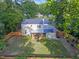 Aerial view of a fenced yard with green grass, landscaping, patio, and mature trees surrounding at 4 Galaxy Ct, Durham, NC 27705
