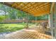 Inviting back deck with wooden flooring, metal chairs, and a view of the private, green backyard at 4 Galaxy Ct, Durham, NC 27705