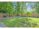 Well-manicured backyard with healthy green lawn and surrounded by a wood fence and mature trees at 4 Galaxy Ct, Durham, NC 27705