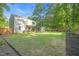 Expansive backyard featuring a well-manicured lawn, a wooden fence, and a covered deck at 4 Galaxy Ct, Durham, NC 27705