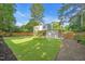Large, level backyard with green grass, a wood fence, garden, and trees at 4 Galaxy Ct, Durham, NC 27705