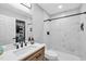 Modern bathroom featuring a tiled shower, wood vanity, updated fixtures, and marble-look tile at 4 Galaxy Ct, Durham, NC 27705