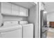 Clean laundry room featuring modern appliances, built-in cabinets, and a neutral color scheme at 4 Galaxy Ct, Durham, NC 27705