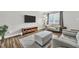 Bright living room featuring modern gray furniture, hardwood floors, and natural light from a large window at 4 Galaxy Ct, Durham, NC 27705